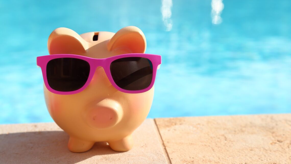 Sparschwein mit Sonnenbrille vor einem Schwimmbecken