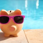 Sparschwein mit Sonnenbrille vor einem Schwimmbecken