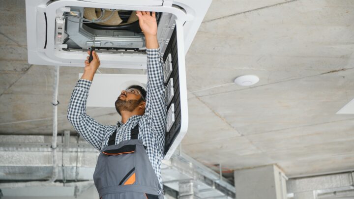 Monteur führt Wartung an Klimaanlage im Gebäude durch | elektrische Notheizung