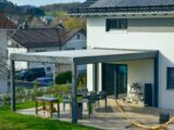 Moderne Terrasse mit Terrassendacheindeckung und Sitzbereich im Garten
